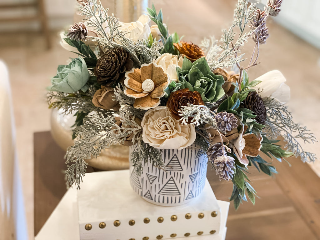 christmas dinner table arrangement made of sola wood flowers and faux greenery